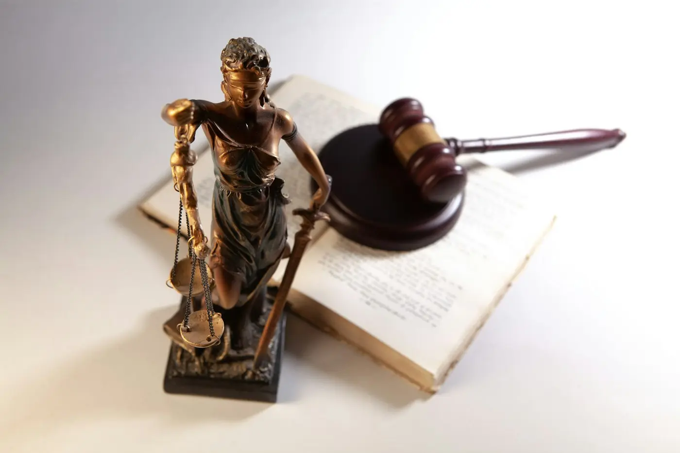 Statue of Lady Justice, a gavel and an open law book