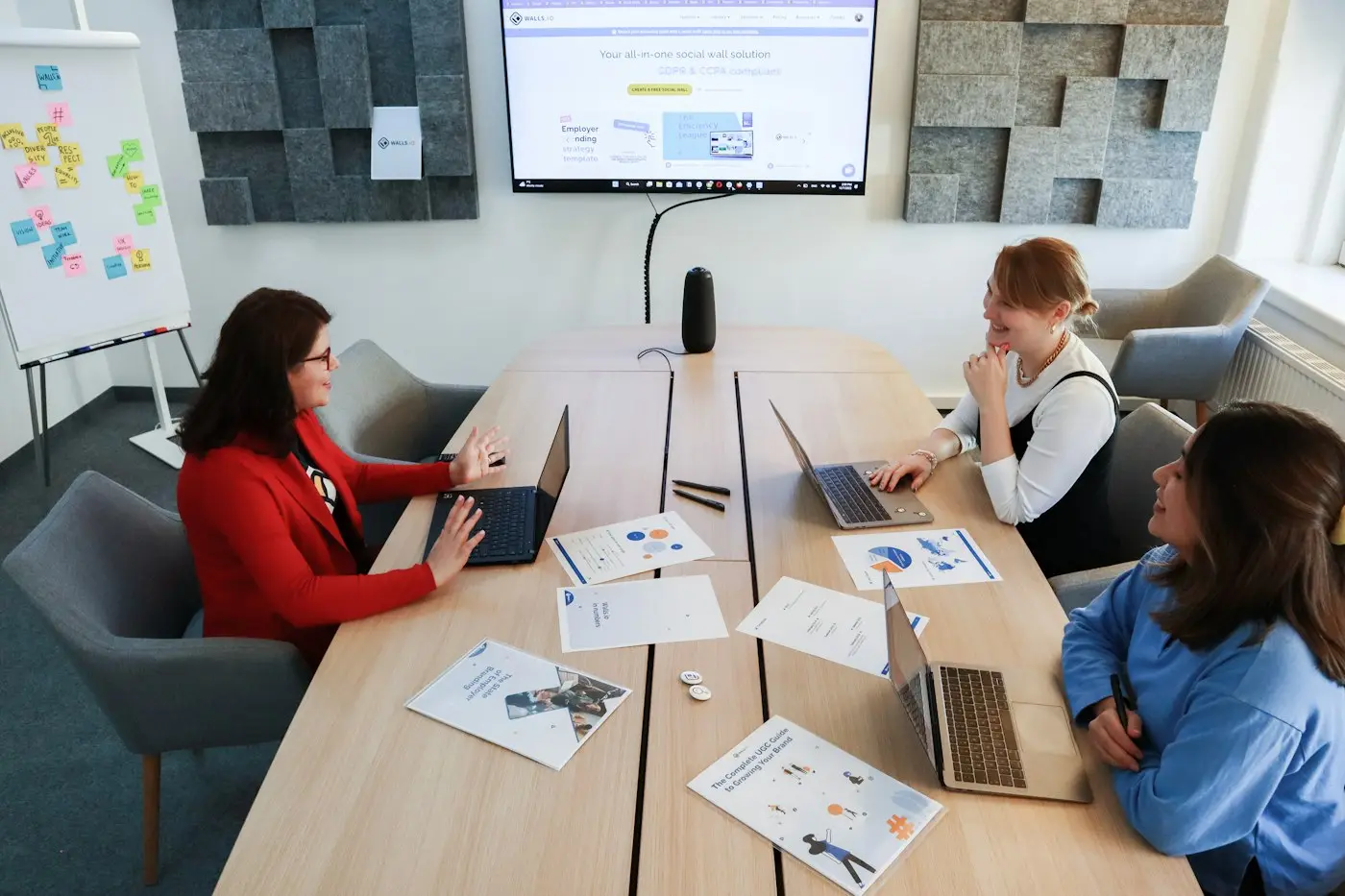 Marketing team working together at a conference table with laptops